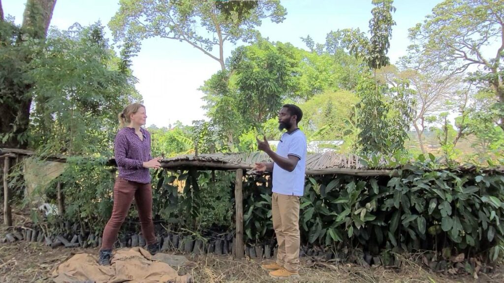 Tina Teucher und Bemeriki Bisimwa Dusabe stehen in der Baumschule des Permakultur-Gartens in der Flüchtlingssiedlung Rwamwanja, Uganda.