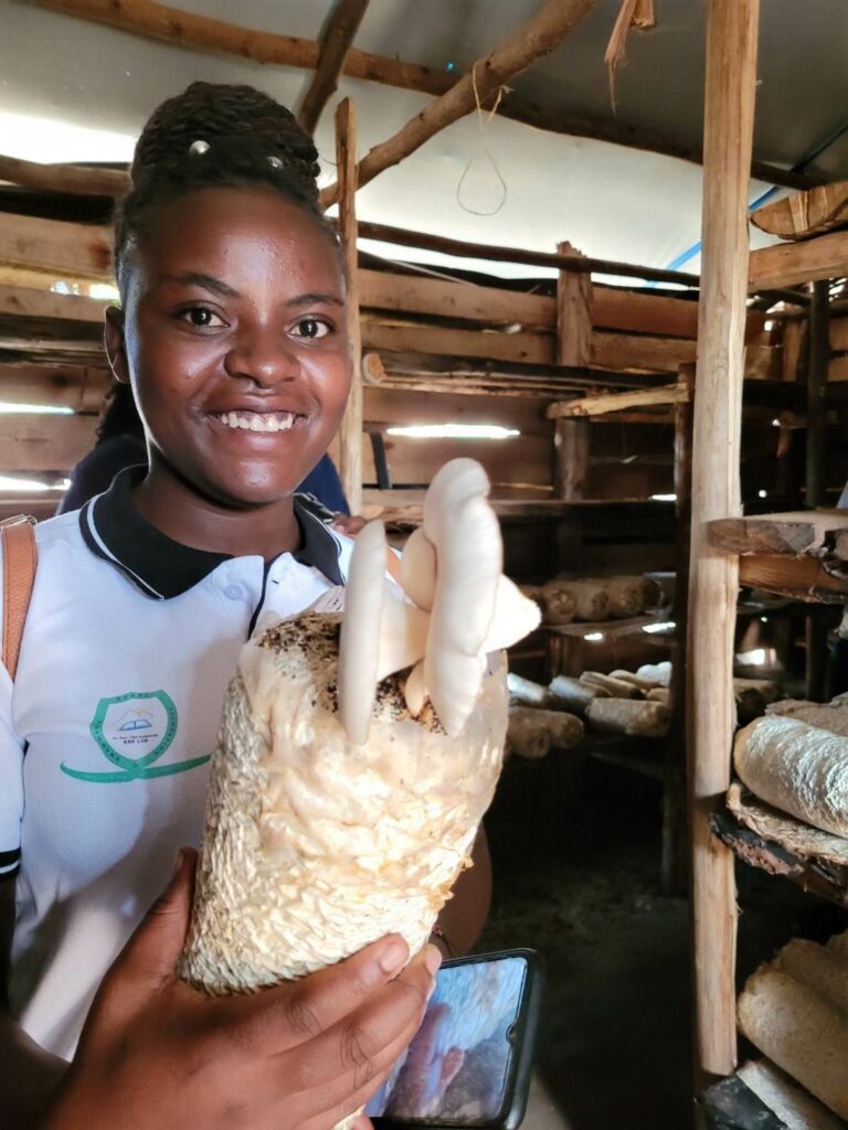 Jackline vom Team der Rwamwanja Rural Foundation zeigt die Pilzproduktion