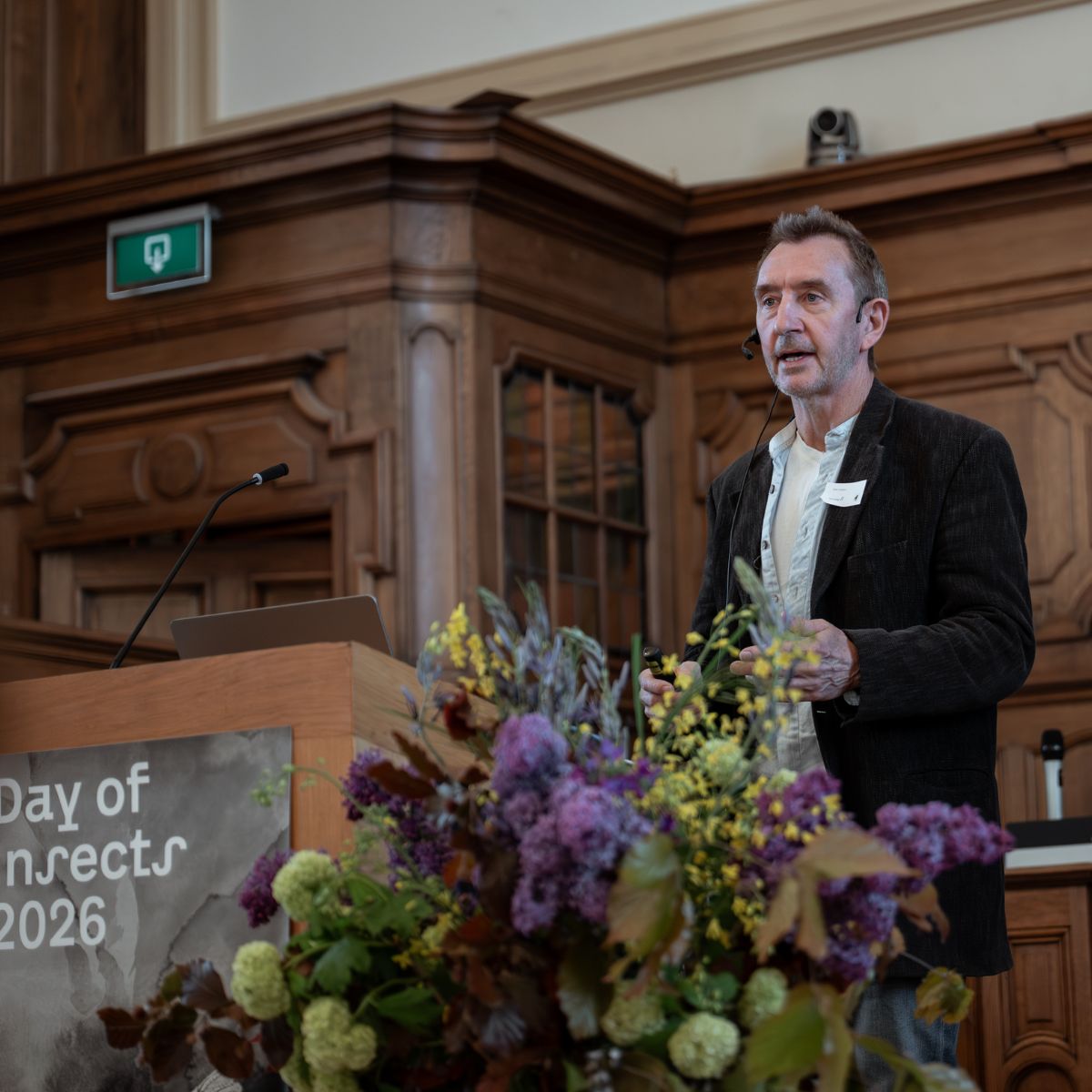 Dave Goulson am Podium mit großem Blumenstrauch im Vordergrund, Day of Insects 2026