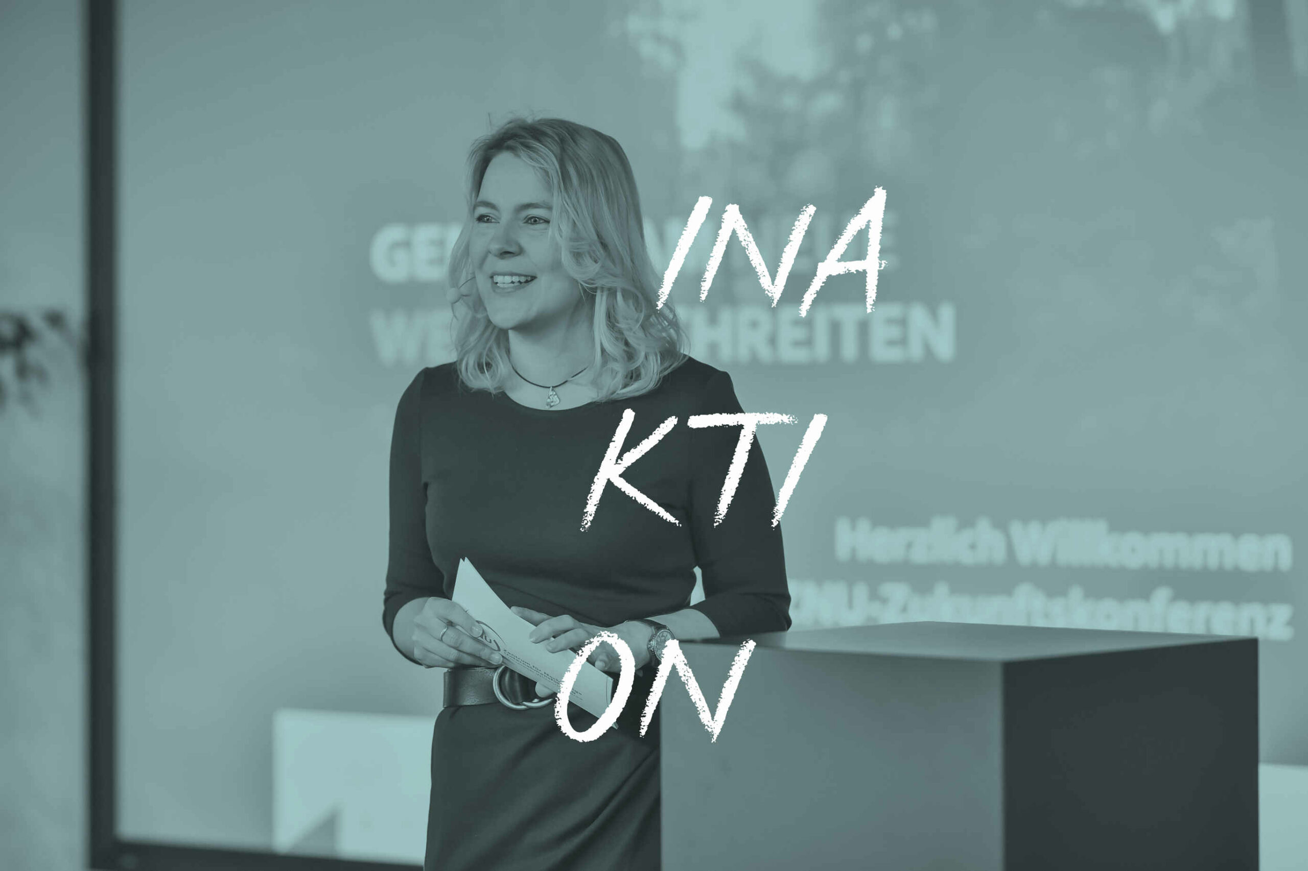 Tina Teucher hält Vortrag, Text: "INA KTI ON"