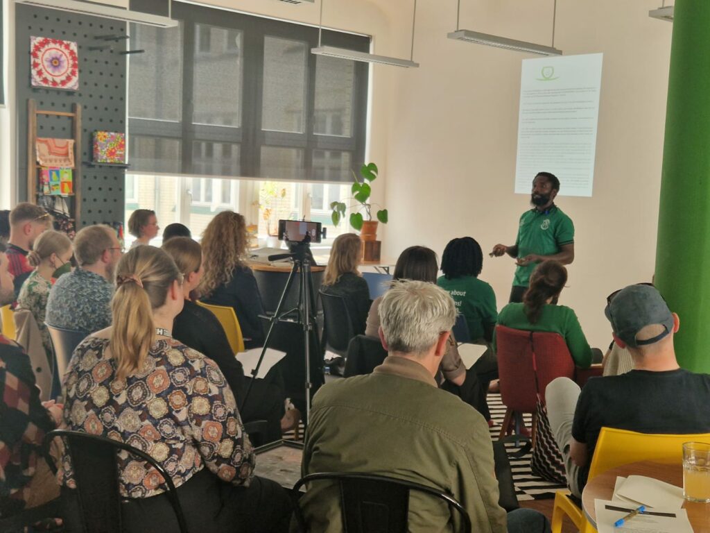 Bemeriki Bisimwa Dusabe hält einen Vortrag vor Publikum für Tina Teuchers Initiative Generation Restoration in Berlin