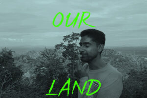 OurLand Co-founder Vijo Varghese With A Flower In Front Western Forest Complex In Thailand; Text On Picture: OUR LAND