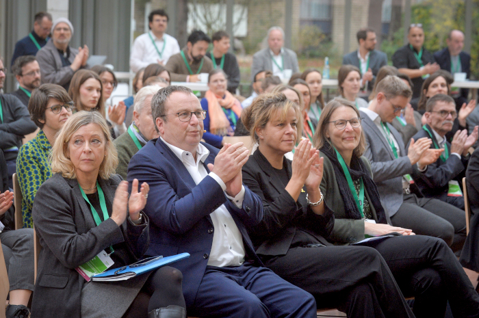 Applaudierendes Publikum mit NRW-Wirtschaftsministerin Mona Neubaur und NRW-Umweltminister Krischer in der ersten Reihe